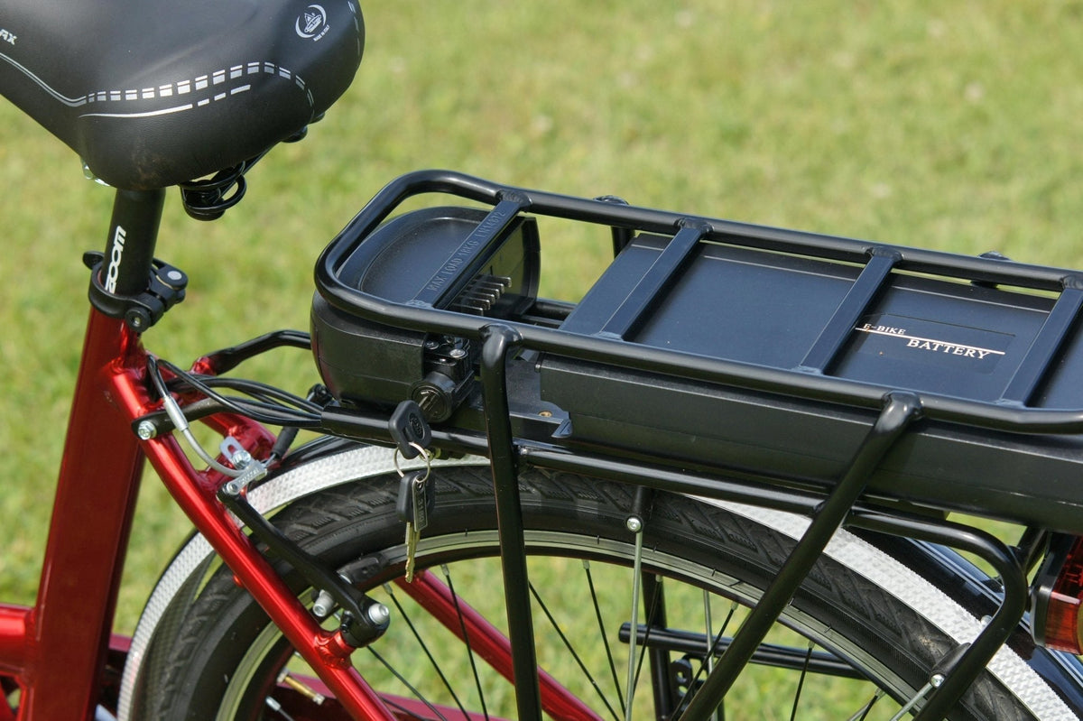 Batteria di una bici elettrica sul portapacchi con la chiave nella serratura – assicurazione per bici e monopattino