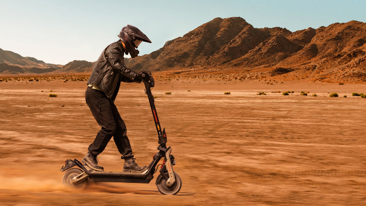 Pilota con casco su un monopattino elettrico Ninebot GT3 in una piana sabbiosa – monopattino per persone pesanti