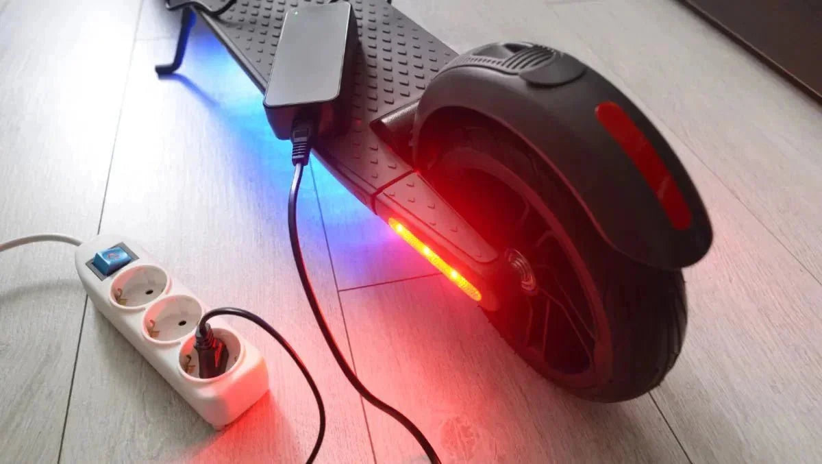 Monopattino elettrico in carica in casa con il caricatore collegato a una presa multipla – aumentare l’autonomia