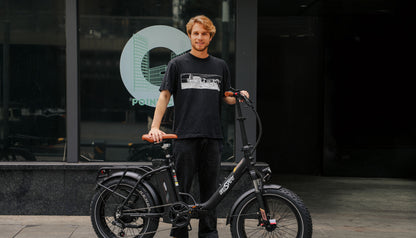 OneSport OT16 Max Elcykel svart med en kille som står och håller i elcykeln