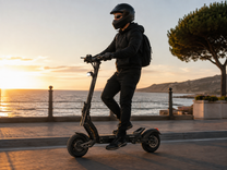 Uomo alla guida del monopattino elettrico BOYUEDA G6 in riva al mare