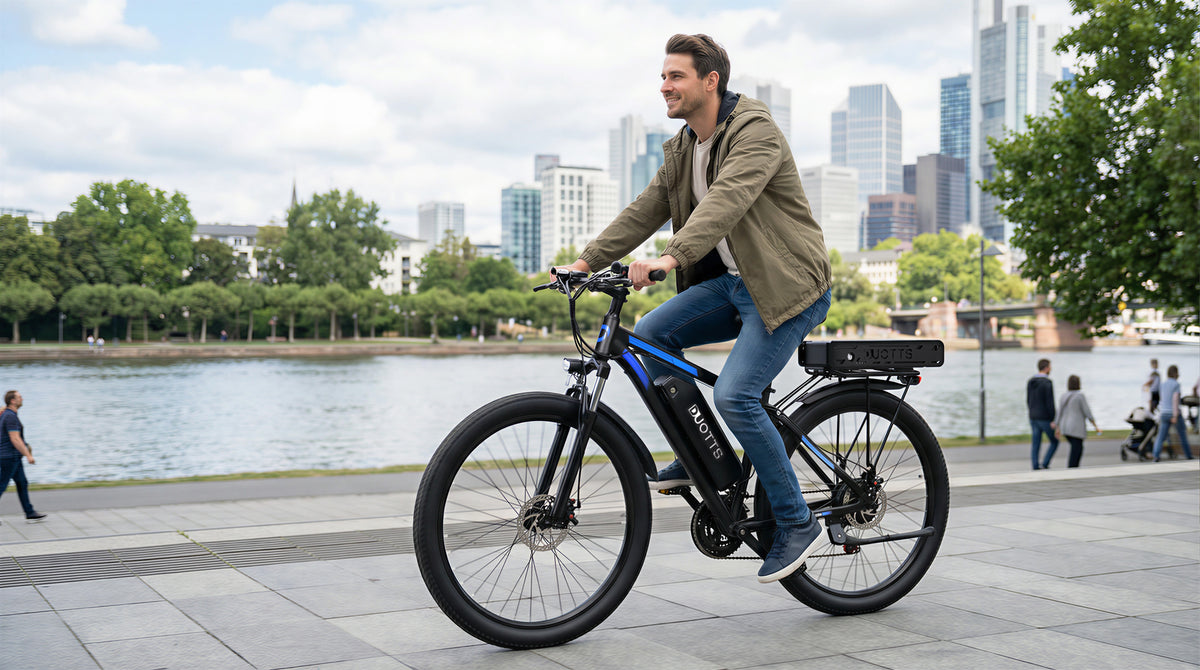 Uomo alla guida della bici elettrica Duotts C29-K su un vialetto in riva a un lago