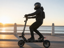 Uomo alla guida del monopattino elettrico DUALTRON VICTOR LIMITED al tramonto