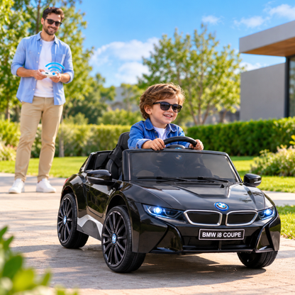 Bambino alla guida dell'auto elettrica per bambini BMW i8 Coupé con un adulto accanto