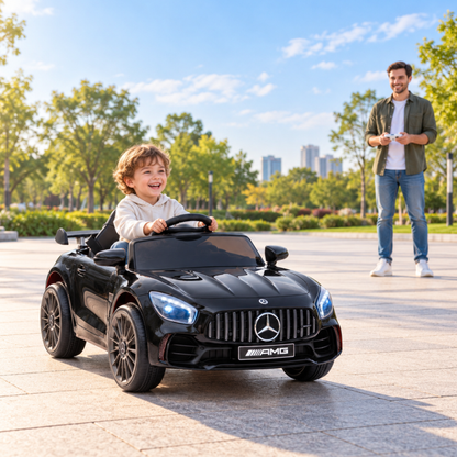 Bambino alla guida dell'auto elettrica per bambini Mercedes AMG GT con un adulto accanto in colore nero