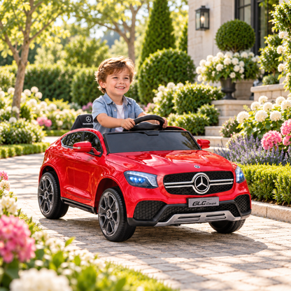 Bambino alla guida dell'auto elettrica per bambini Mercedes GLC Coupé in un parco