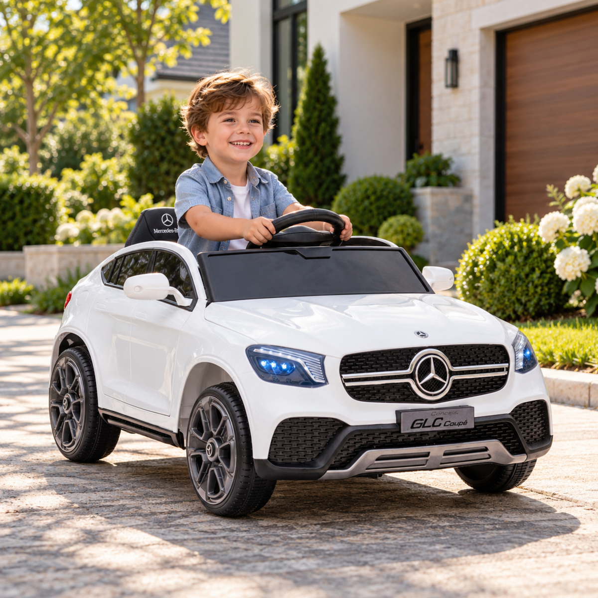 Bambino alla guida dell'auto elettrica per bambini Mercedes GLC Coupé in colore bianco