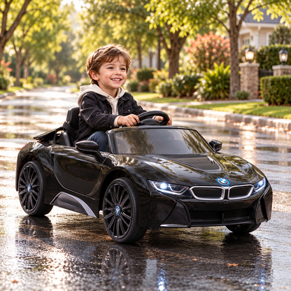 Bambino alla guida dell'auto elettrica per bambini BMW i8 Coupé su un vialetto