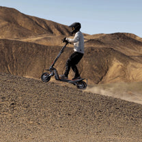 Pilota con il monopattino elettrico NAVEE XT5 Max in fuoristrada nel deserto