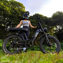 Donna alla guida della fat bike elettrica TST R7 in colore nero su un prato