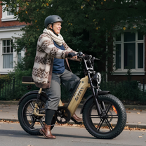 Persona alla guida della fat bike elettrica TST R7 in colore beige in una strada