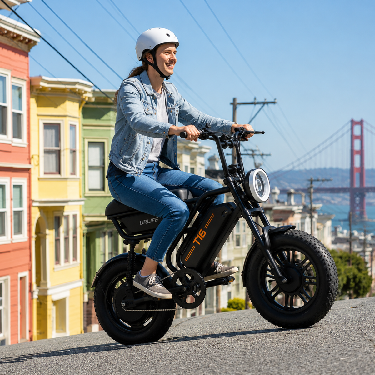 Donna alla guida della fat bike elettrica URLIFE T16 in colore nero con il casco in una strada