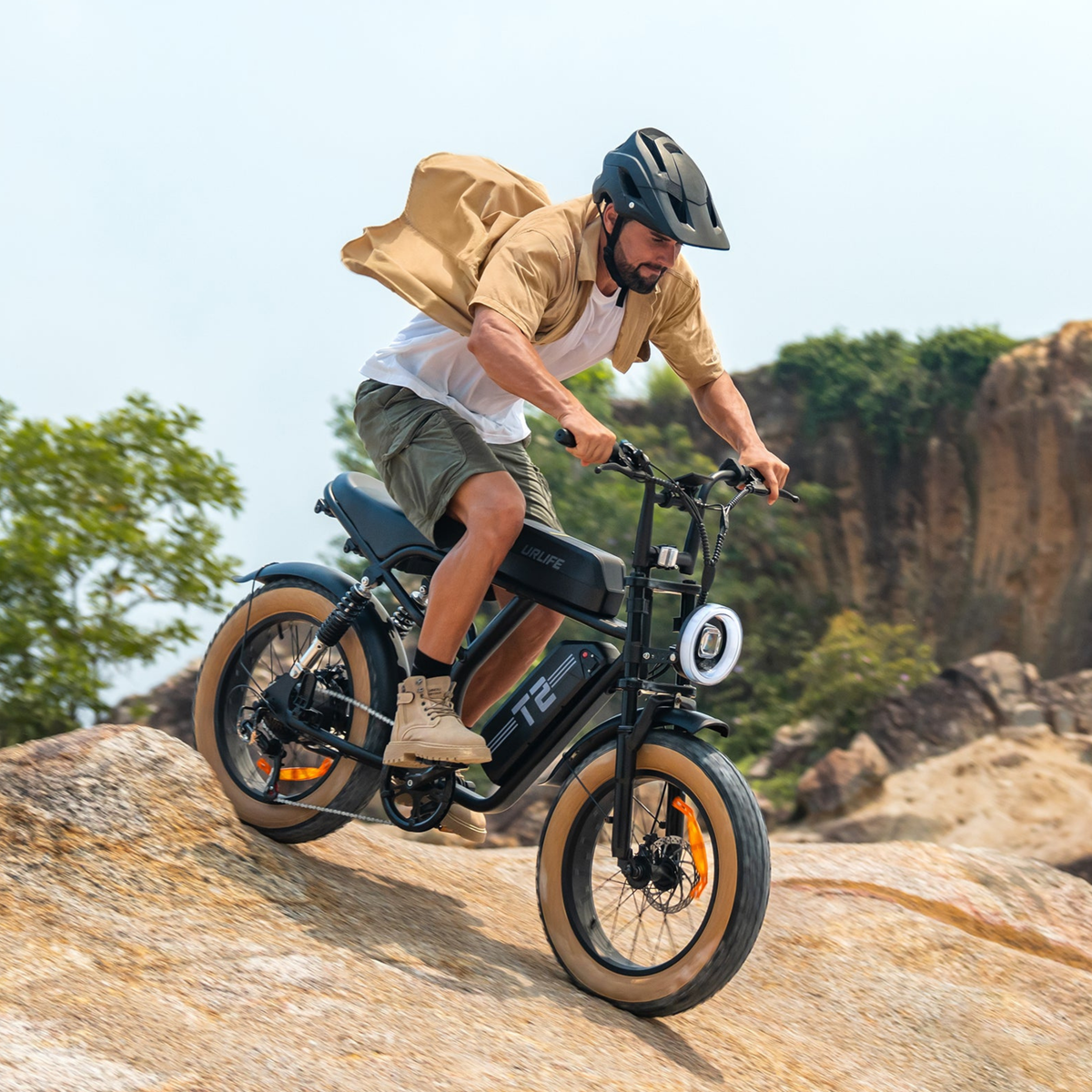 Pilota con la fat bike elettrica URLIFE T2 in fuoristrada con il casco