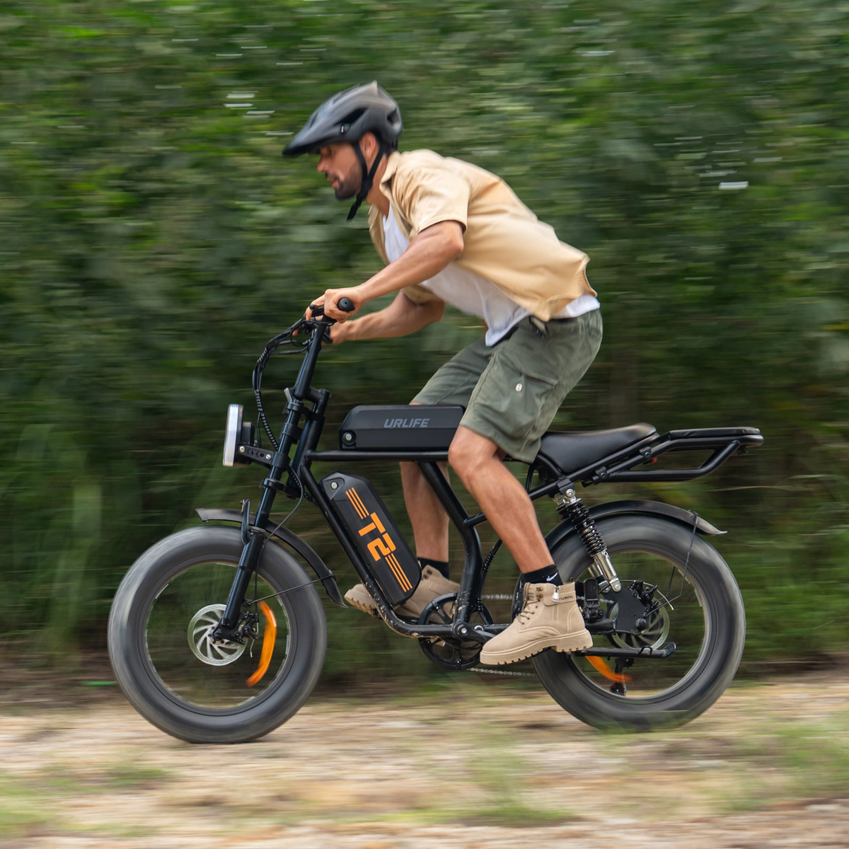 Uomo alla guida della fat bike elettrica URLIFE T2 in colore nero con il casco su un sentiero