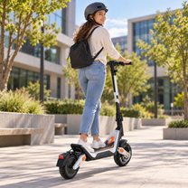 Wheely - J18 monopattino elettrico visto da dietro con conducente con casco e zaino tra alberi ed edifici