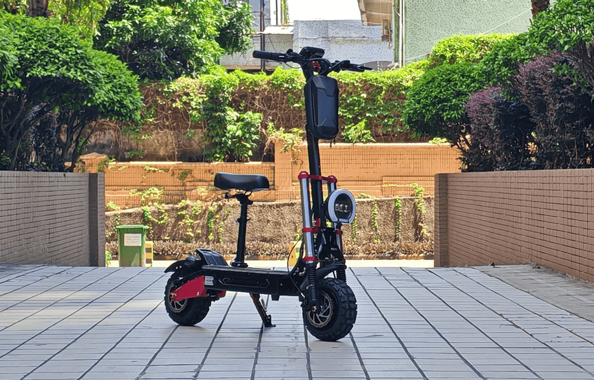 Monopattino elettrico BOYUEDA S5-11 visto di lato con sellino in un giardino