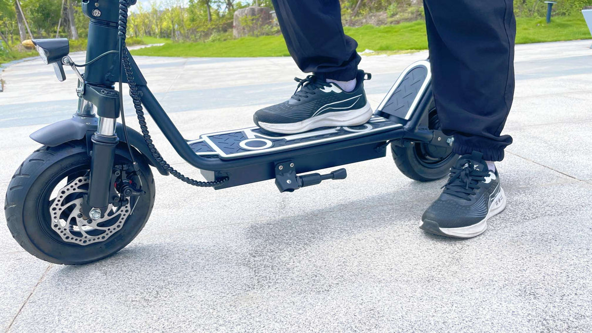 Persona alla guida del monopattino elettrico DriveTron DT01 in una strada