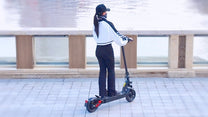 Donna in piedi con il monopattino elettrico DriveTron DT08 in città