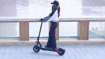 Donna alla guida del monopattino elettrico DriveTron DT08 in città