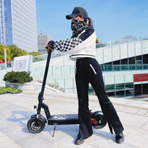 Donna in piedi con il monopattino elettrico DriveTron DT08 in città