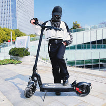 Donna in piedi con il monopattino elettrico DriveTron DT08 in una strada