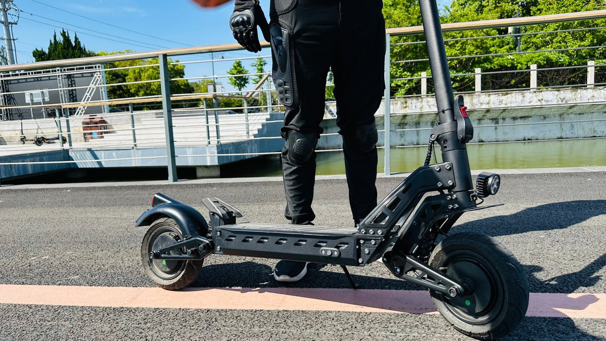 Persona alla guida del monopattino elettrico DriveTron DT10 in una strada