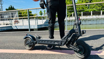 Persona alla guida del monopattino elettrico DriveTron DT10 in una strada