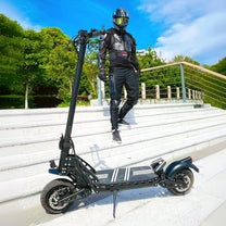 Uomo in piedi con il monopattino elettrico DriveTron DT10 in città