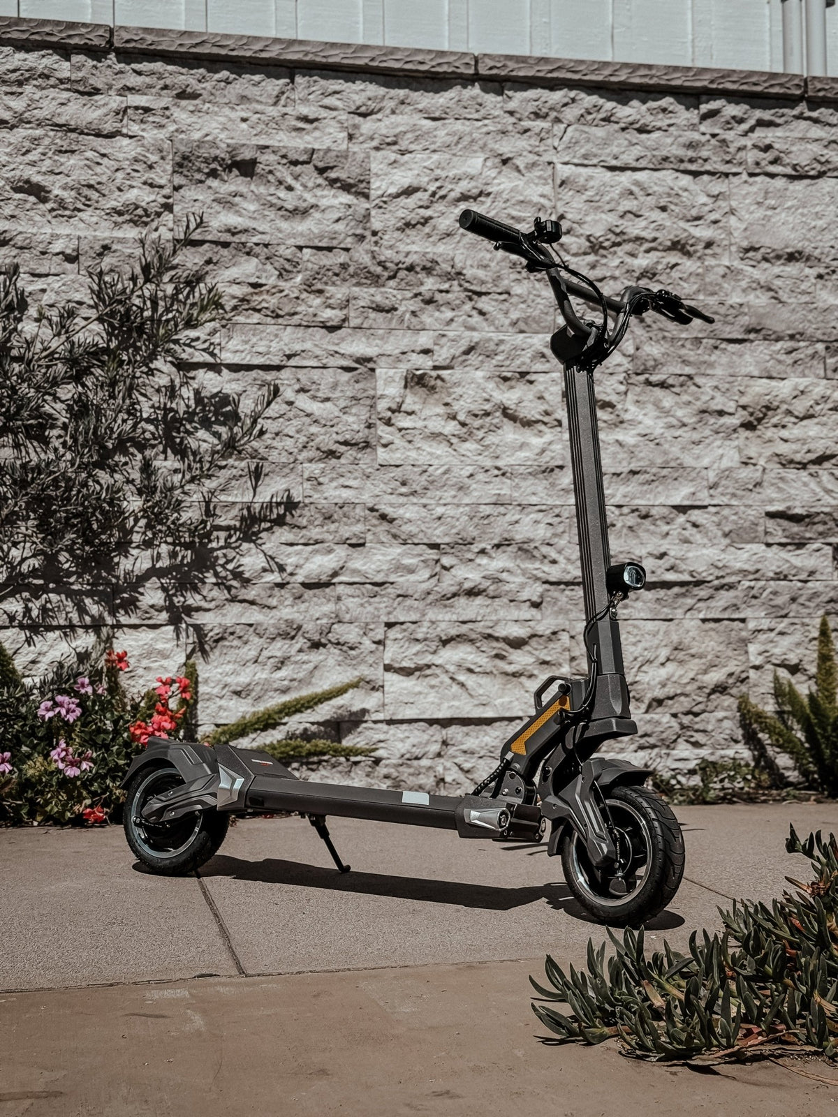 Monopattino elettrico DUALTRON TOGO visto di tre quarti in un giardino