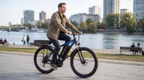 Uomo alla guida della bici elettrica Duotts C29-K su un vialetto