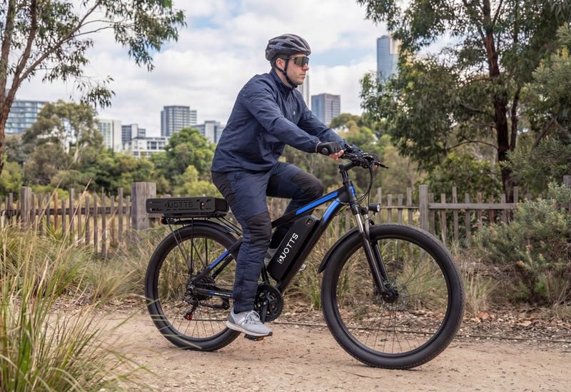 Uomo alla guida della bici elettrica Duotts C29-K in un parco