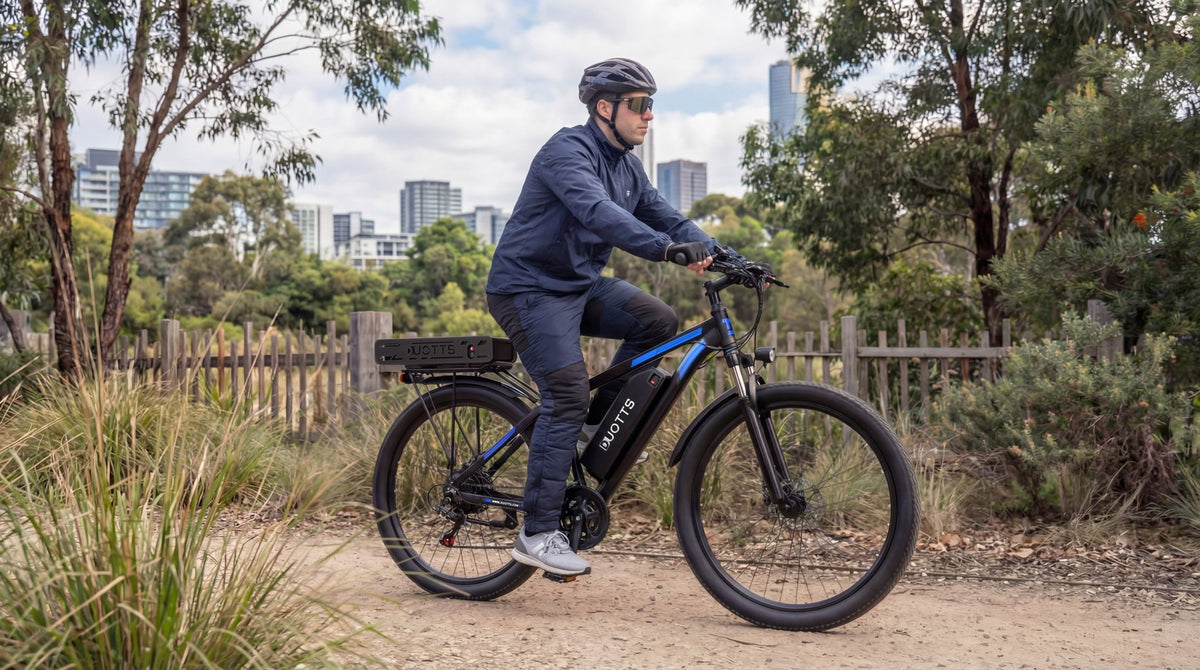 Uomo alla guida della bici elettrica Duotts C29-K in un parco