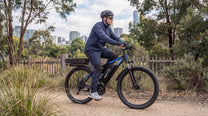 Uomo alla guida della bici elettrica Duotts C29-K in un parco