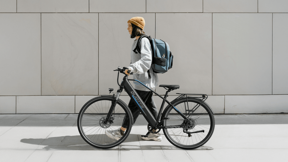 Uomo in piedi con la bici elettrica Duotts C29 Lite
