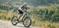 Uomo alla guida della fat bike elettrica Duotts E26 su un vialetto