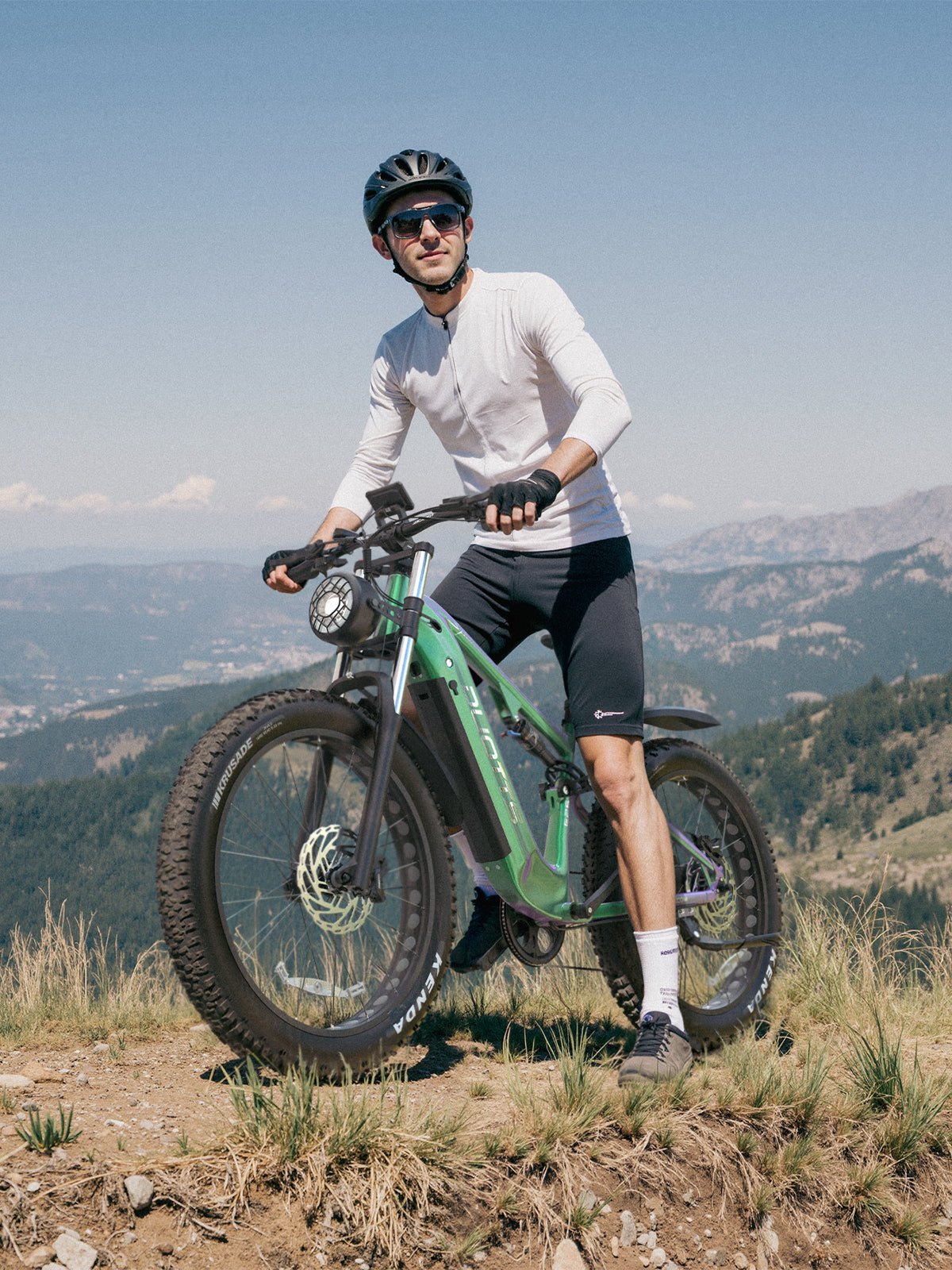 Uomo in piedi con la fat bike elettrica Duotts E26 su un prato
