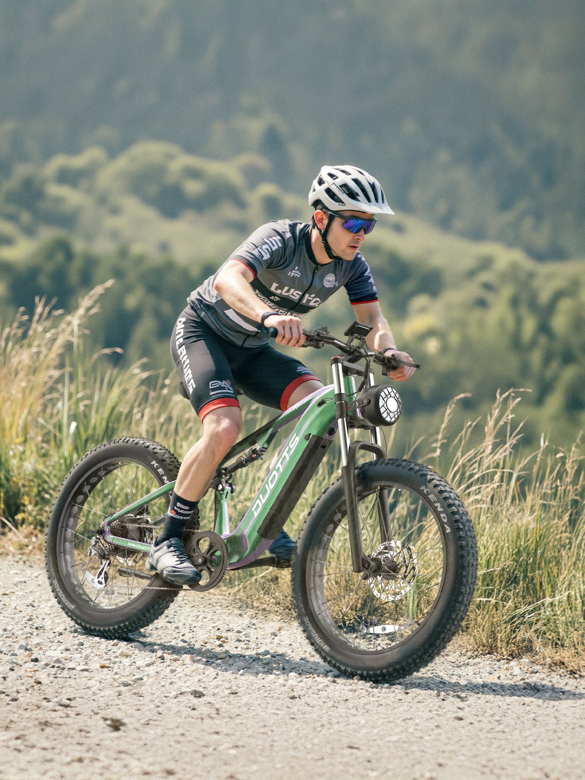 Uomo alla guida della fat bike elettrica Duotts E26 su un vialetto