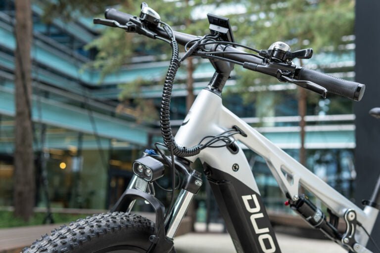 Persona alla guida della mountain bike elettrica Duotts E29 in città
