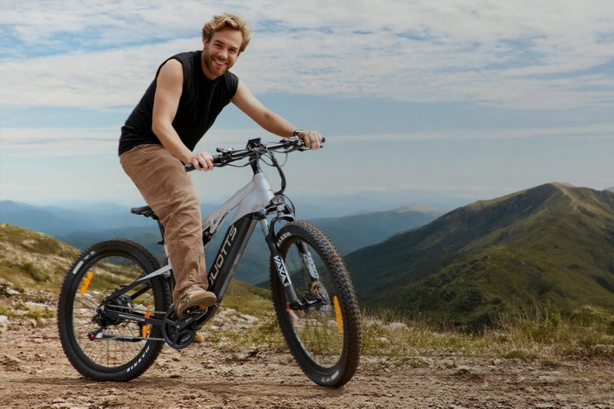 Uomo in piedi con la mountain bike elettrica Duotts E29 su un prato