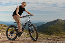 Uomo in piedi con la mountain bike elettrica Duotts E29 su un prato