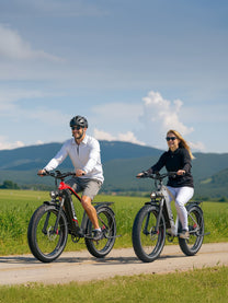 Due persone con la fat bike elettrica Duotts F26 Lite su un prato