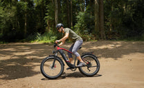 Uomo alla guida della fat bike elettrica Duotts F26 Lite su un vialetto