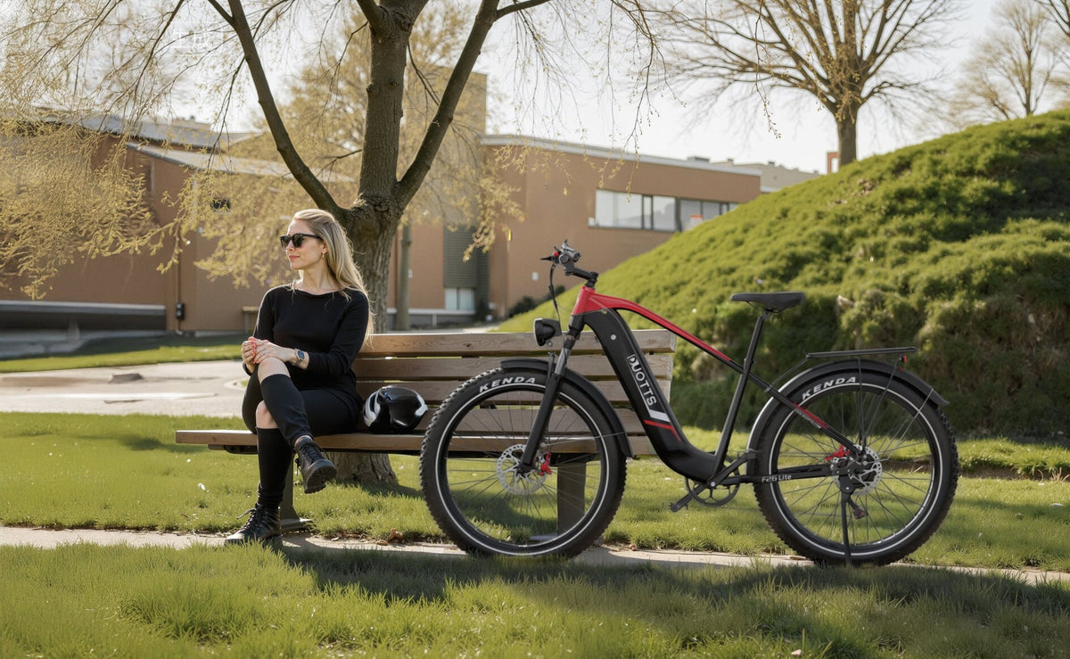 Persona seduta accanto alla fat bike elettrica Duotts F26 Lite in un parco