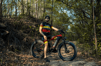 Pilota con la fat bike elettrica Duotts F26 in fuoristrada nel bosco