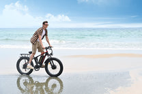 Uomo alla guida della fat bike elettrica Duotts S26 in riva al mare