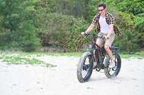 Uomo alla guida della fat bike elettrica Duotts S26 in riva al mare