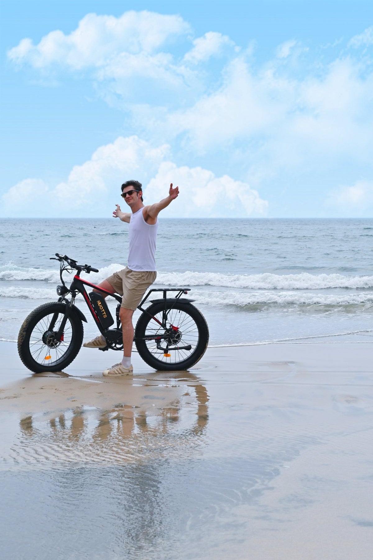 Uomo in piedi con la fat bike elettrica Duotts S26 in riva al mare