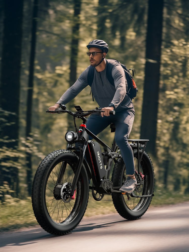 Uomo alla guida della fat bike elettrica Duotts S26 nel bosco