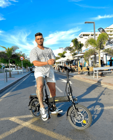 Uomo in piedi con la bici elettrica pieghevole DYU A1F Pro in città