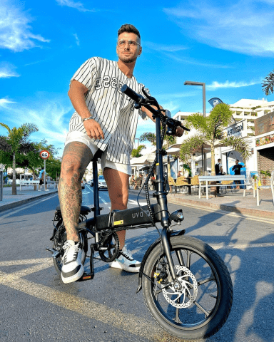 Uomo in piedi con la bici elettrica pieghevole DYU A1F Pro in città